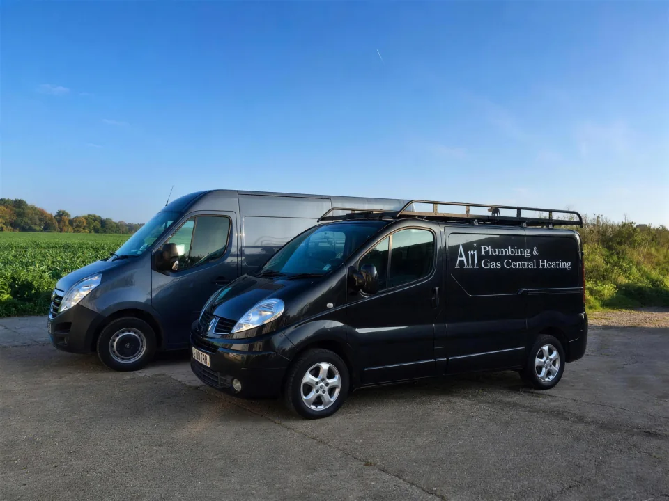 Ari Plumbing and Heating vans in a rural setting